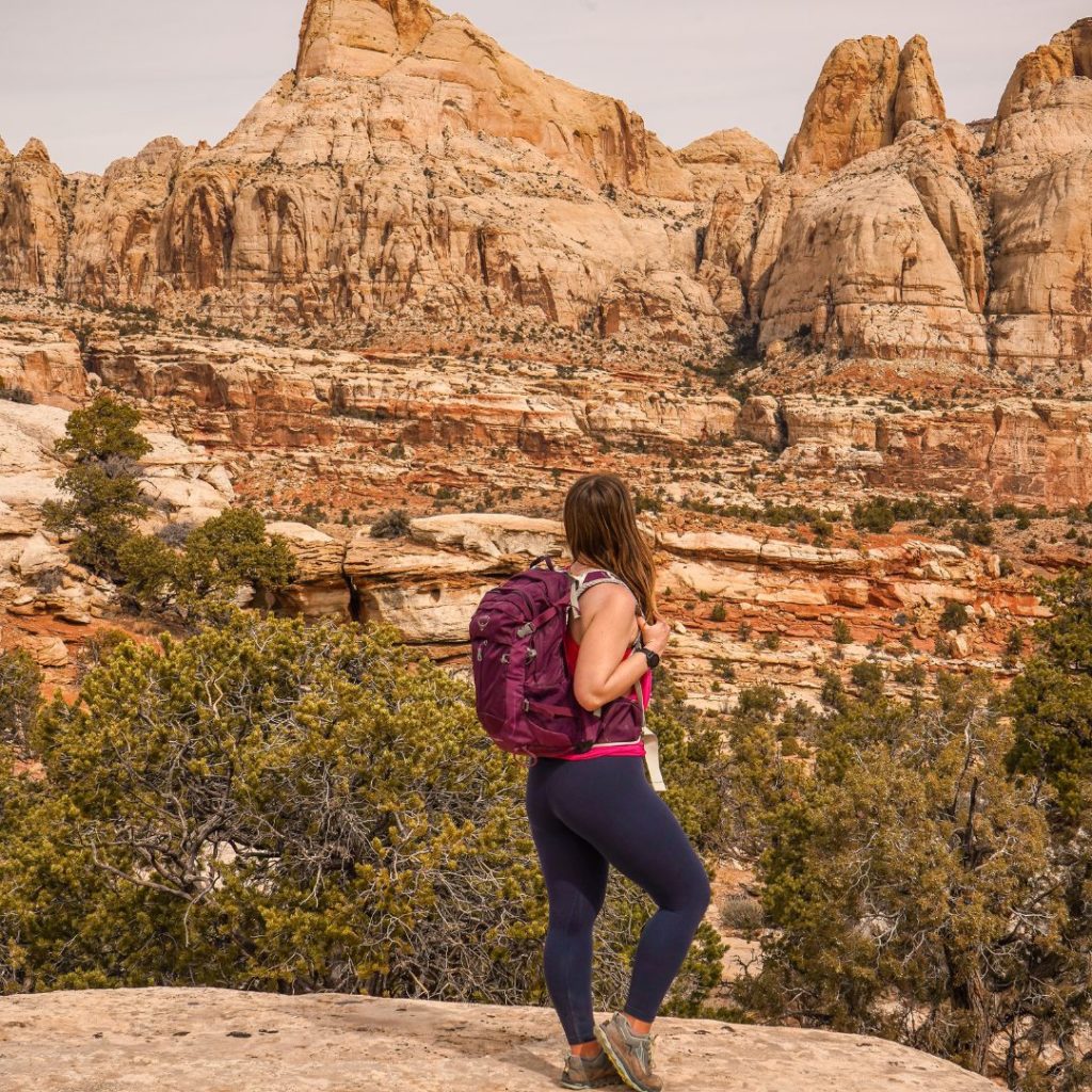Woman wearing a backpack hiking in Capitol Reef National Park.