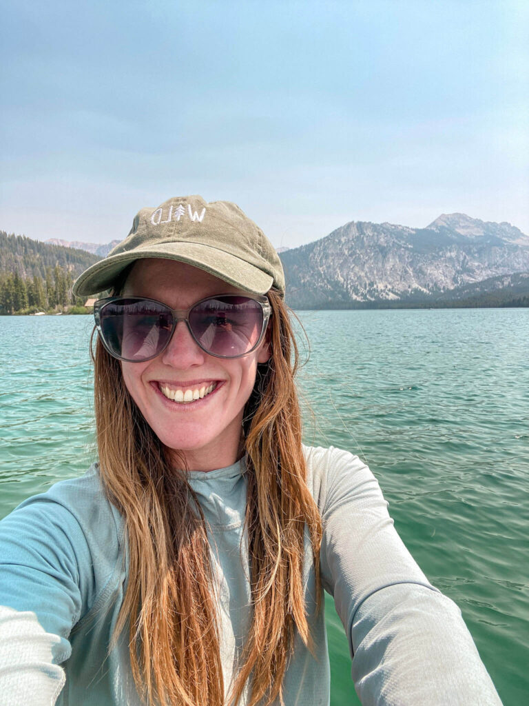 Woman taking a selfie wearing sun protection while paddleboarding in Idaho.