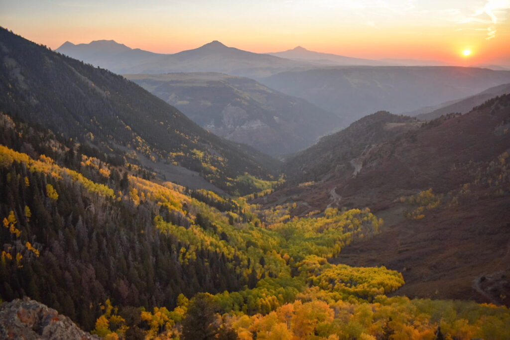 Overlooking a golden aspen forest in the mountains at sunset along Last Dollar Road in Telluride, Colorado.