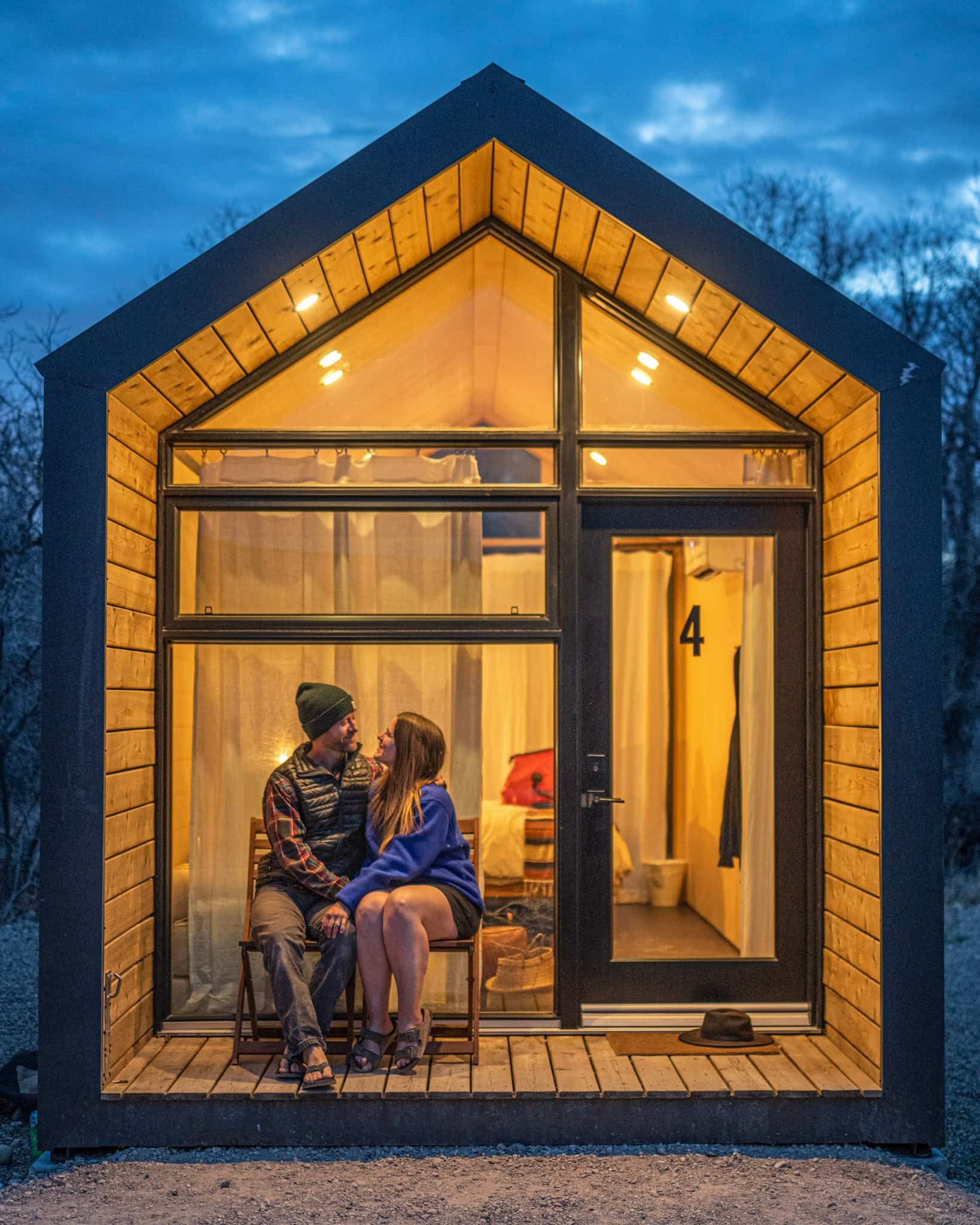 A couple sits outside of a modern cabin at Yonder Escalante in Utah.