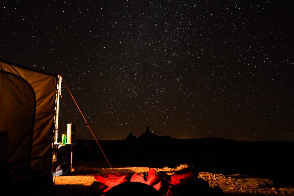 Photo of a campsite at night with stars shining.